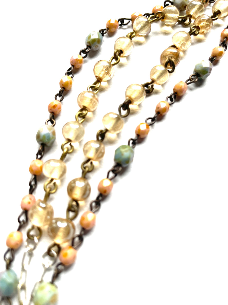 close up of beaded chain, copper metal, peach, green and golden glass beads